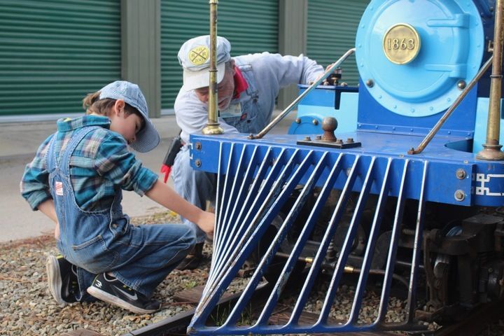 young boy and older man checking out train engine